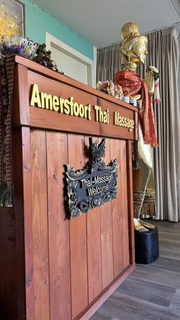 Reception desk of Amersfoort Thai Massage with a gilded Thai statue
