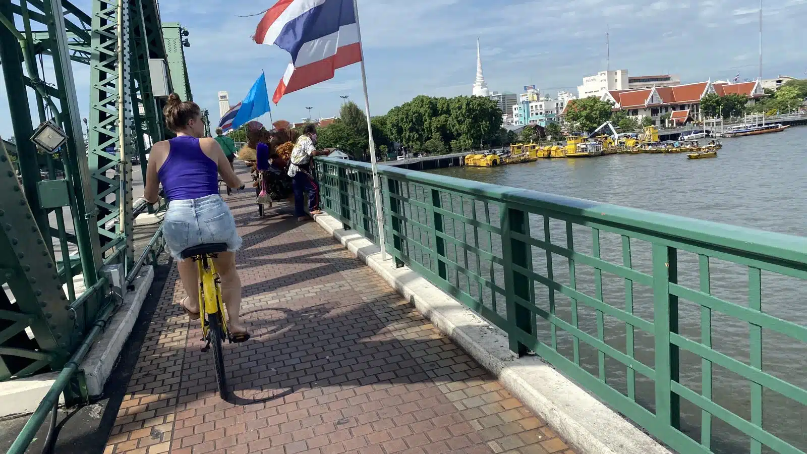 Cycling over Memorial Bridge with a view of the Chao Phraya River in Bangkok