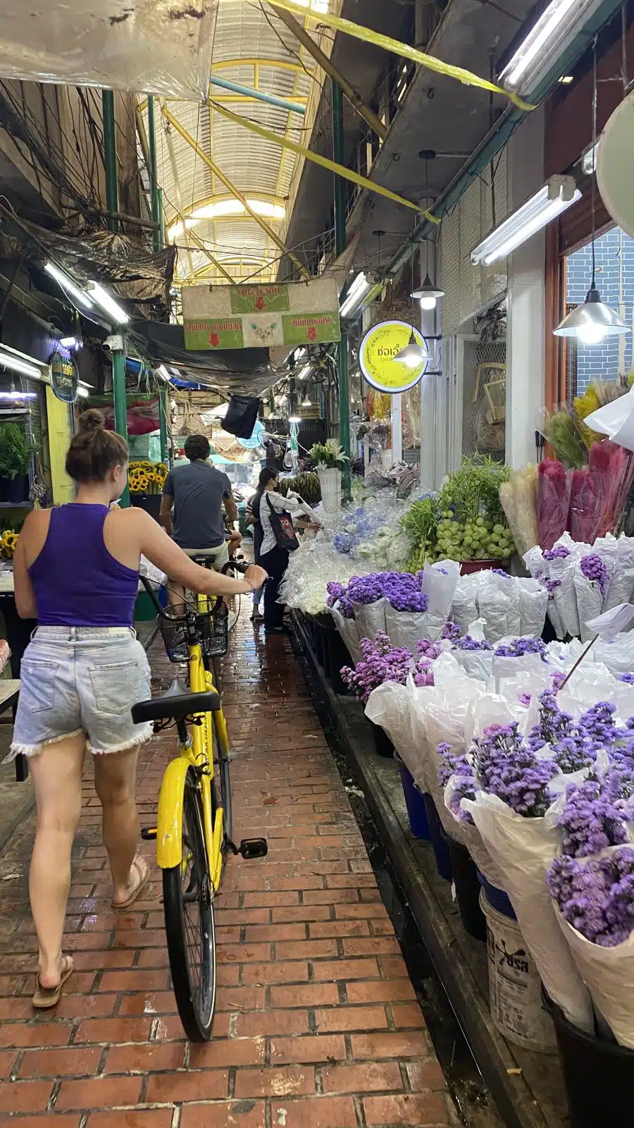 Walking a bike through Pak Khlong Talat flower market in Bangkok