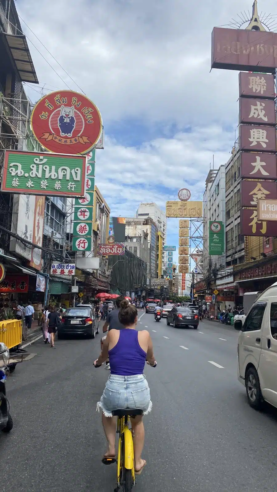 Cycling down Yaowarat Road in Bangkok Chinatown with big Chinese signs